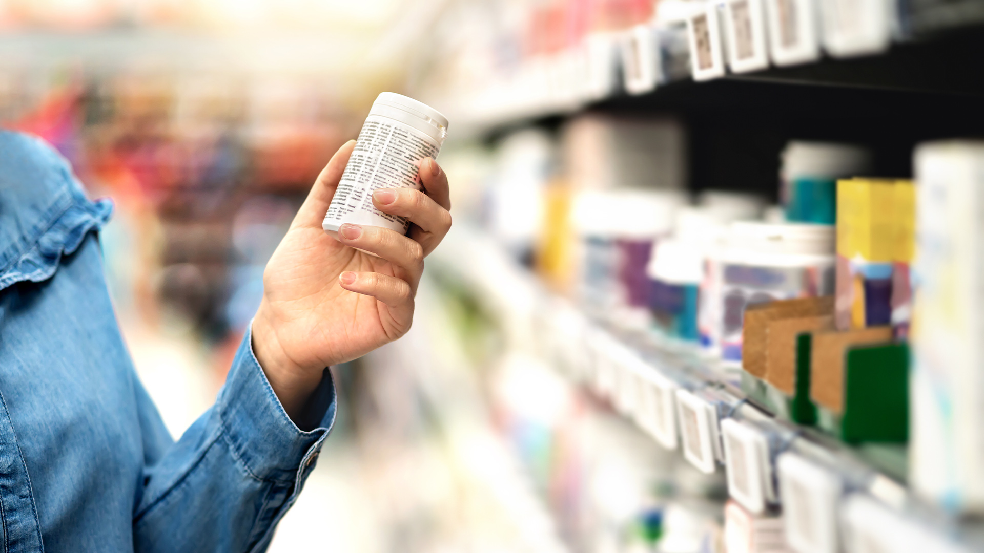 Woman's hand holding bottle with pills