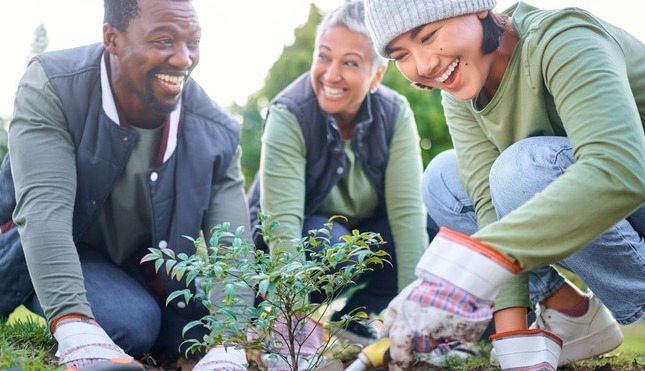 Friends smiling while gardening outside
