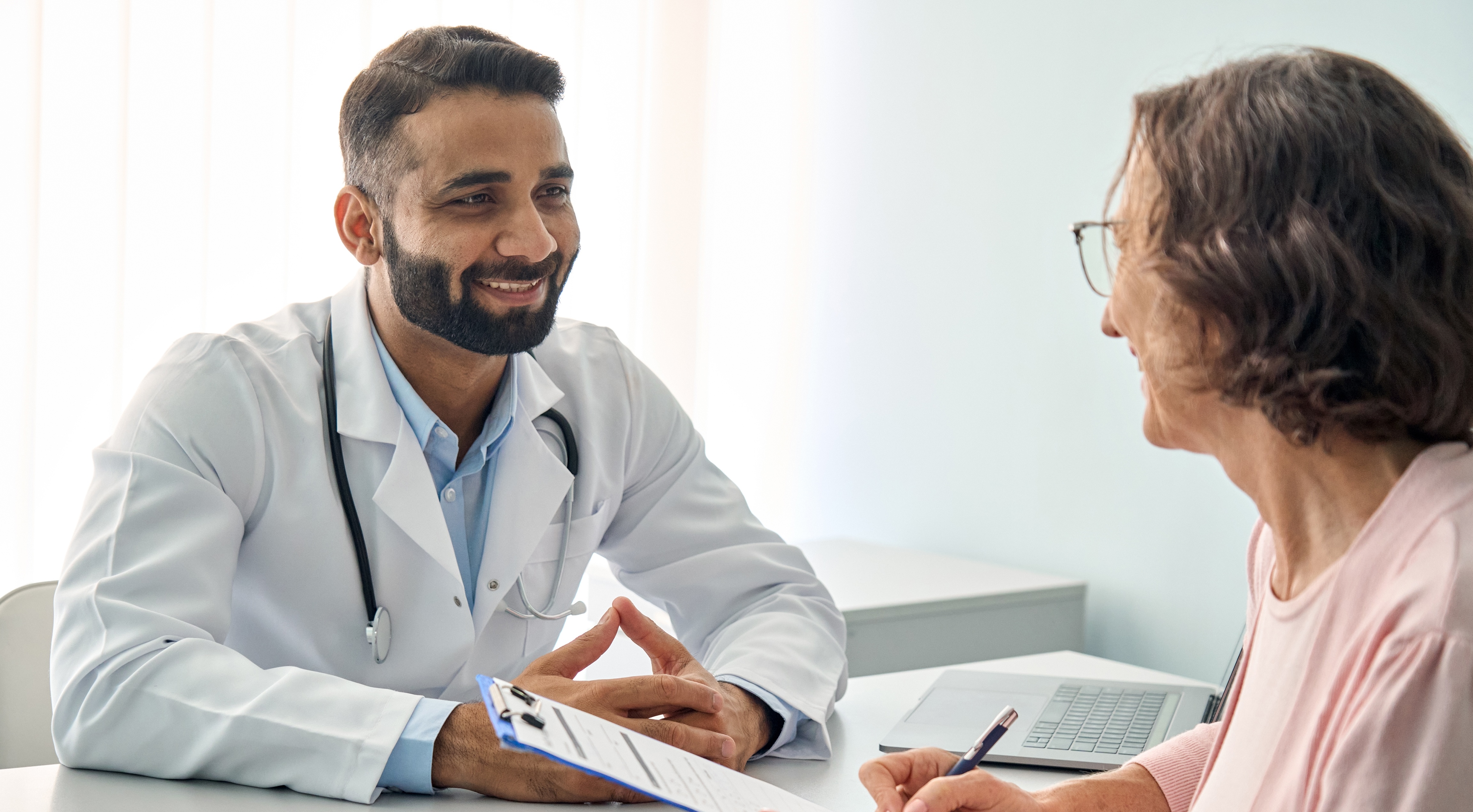 Male doctor consulting female patient during a check up appointment.